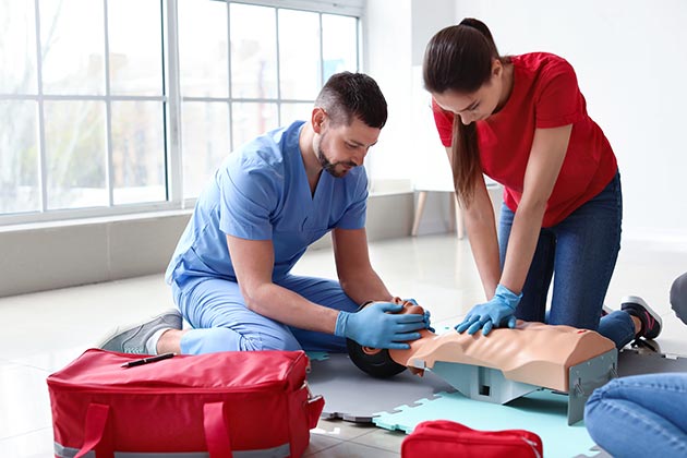 Man and Woman Practicing CPR in AED CPR First Aid Class | AEDCPR